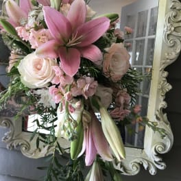 Pink lilies and pale roses in a hand-tied bouquet
