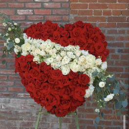 Heart-shaped rose arrangement on an easel with red and white roses