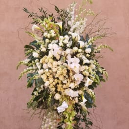 Tall white floral spray with orchids, roses, and calla lilies