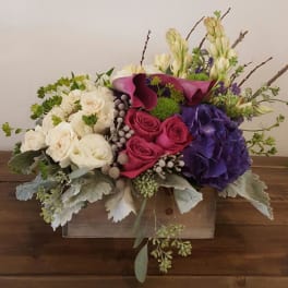 Mixed bouquet with white, pink, and purple flowers in a wooden box