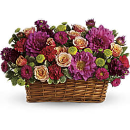 Mixed pink and peach flowers in a wicker basket