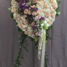 Heart-shaped floral standing spray with pink roses and white blooms