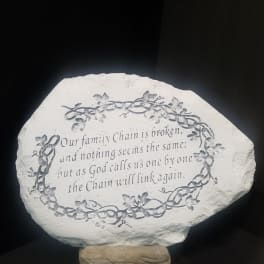 Decorative stone plaque with a memorial quote and floral vine border