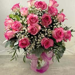 Pink roses arranged in a glass vase with baby's breath