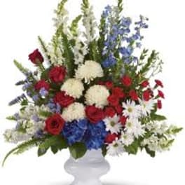 Red, white, and blue floral arrangement in a white vase