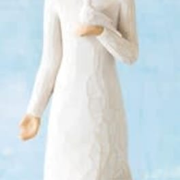 White angel figurine in a long dress against a blue background