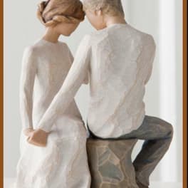 Two carved figurines of a seated couple facing each other