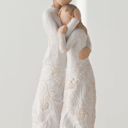 Two carved figures embracing, dressed in white textured clothing