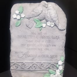 Stone memorial plaque with two doves and floral accents