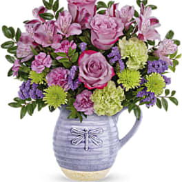 Pink roses and alstroemeria in a lavender ceramic pitcher vase