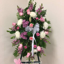Standing floral spray with pink and white flowers on an easel