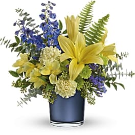 Yellow lilies and blue flowers in a blue vase