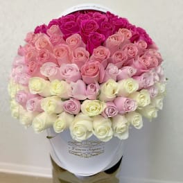 Large ombre arrangement of pink and white roses tightly packed in a white hat box