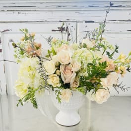 Cream and blush roses arranged in a white vase