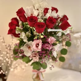 Bouquet of red roses and pink flowers with white butterfly accents