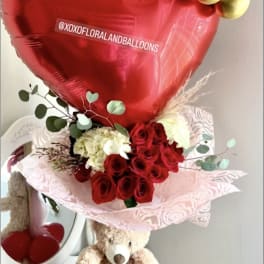 Red heart balloon with roses and a teddy bear gift arrangement