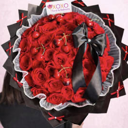 Large bouquet of red roses with a black ribbon and decorative wrap