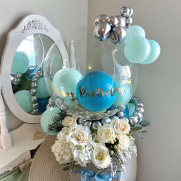 Birthday balloon display with white roses and hydrangeas in a gift box
