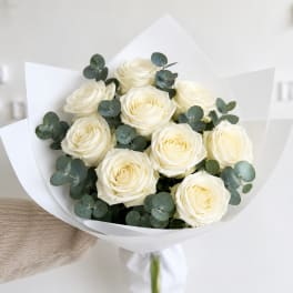 Bouquet of white roses with eucalyptus in white paper wrap