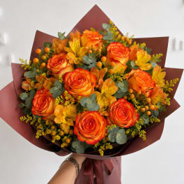 Bouquet of orange roses and yellow alstroemeria with burgundy wrap