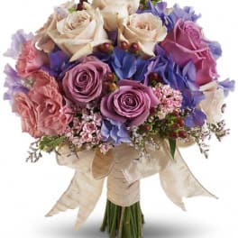 Bouquet of pink, purple, and cream roses with ribbon wrap
