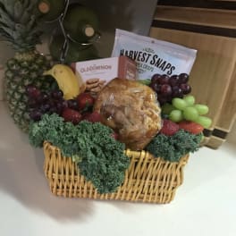 Fruit basket with pineapple, grapes, strawberries, and packaged snacks