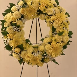 Yellow floral wreath on a black stand