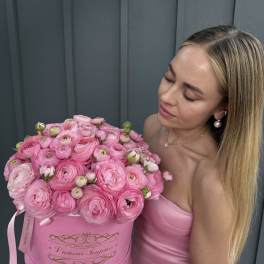 Woman holding a large pink box of pink ranunculus flowers