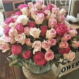 Large bouquet of pink and cream roses in a clear vase