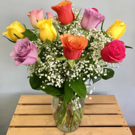 Colorful roses arranged in a clear glass vase
