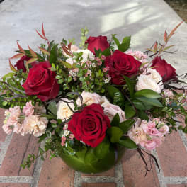 Bouquet of red and pale pink roses in a low vase