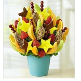 Fruit bouquet in a blue pot with strawberries, melon, and chocolate-dipped pieces