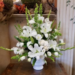 White lilies and roses arranged in a white vase