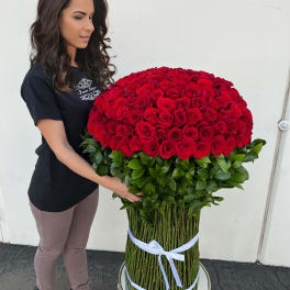 Woman holding a large bouquet of red roses with a green base
