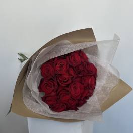 Bouquet of red roses wrapped in brown and white paper