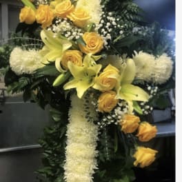 Yellow roses and lilies arranged in a white floral cross