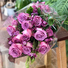 Bouquet of lavender and pink roses wrapped in clear plastic