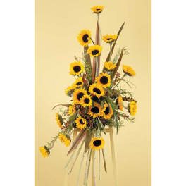 Tall sunflower arrangement with long decorative leaves on a stand
