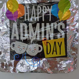 Foil balloon sign reading "Happy Admin's Day" with colorful balloons and coffee cup graphics
