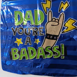 Blue foil balloon with "Dad you're a badass" text and hand gesture graphic