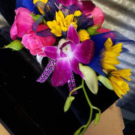 Bouquet of pink roses, yellow daisies, and purple orchids