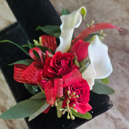 Small bouquet with red roses and white calla lilies tied with a red ribbon