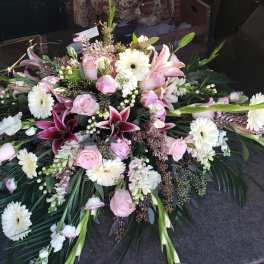 Large pink and white floral casket spray with lilies and daisies