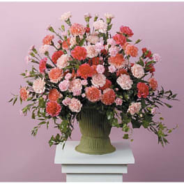 Large bouquet of pink and coral carnations in a green vase