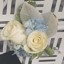 Cream rose boutonniere with pale blue flowers and white shell accents