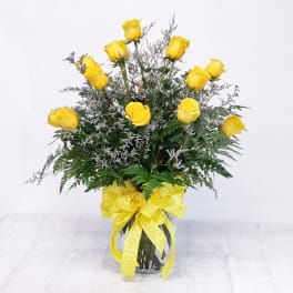 Yellow roses in a glass vase with a yellow ribbon bow