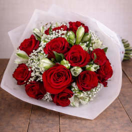 Bouquet of red roses with white filler flowers wrapped in white paper