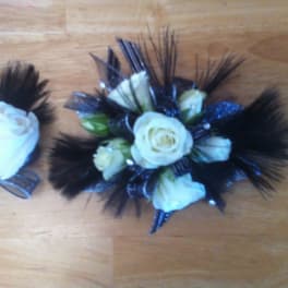 White rose corsage with black feathers and ribbon