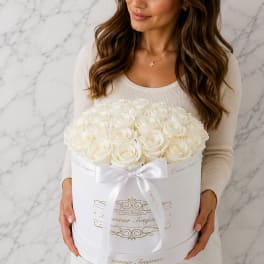 Woman holding a white hatbox of cream roses with a ribbon