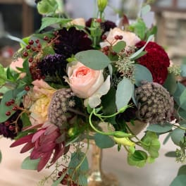 Mixed bouquet with a pale pink rose and burgundy blooms in a glass vase